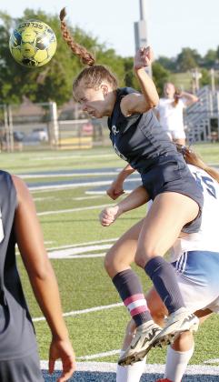 Conley Knapp gets her legs swept out from beneath her while jumping to use her head to redirect a throw-in